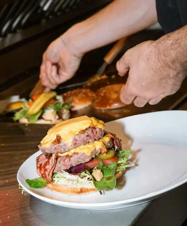 Le burger Quai 18 ouvert sur sa double viande, son fromage et sa garniture